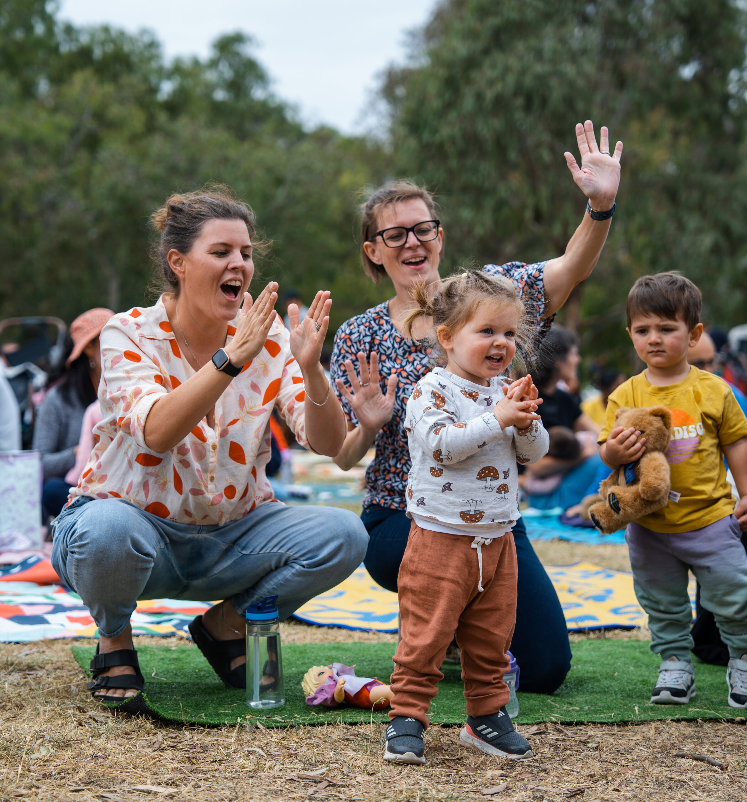 Mothers and their children playing and clapping together