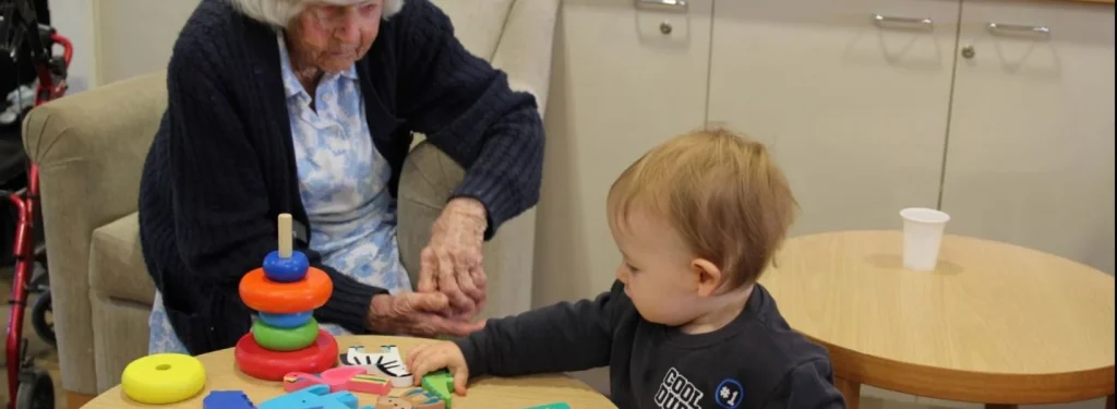 A baby boy and an elderly women playing together