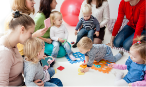 A group of mums with their babies sitting in a circle playing
