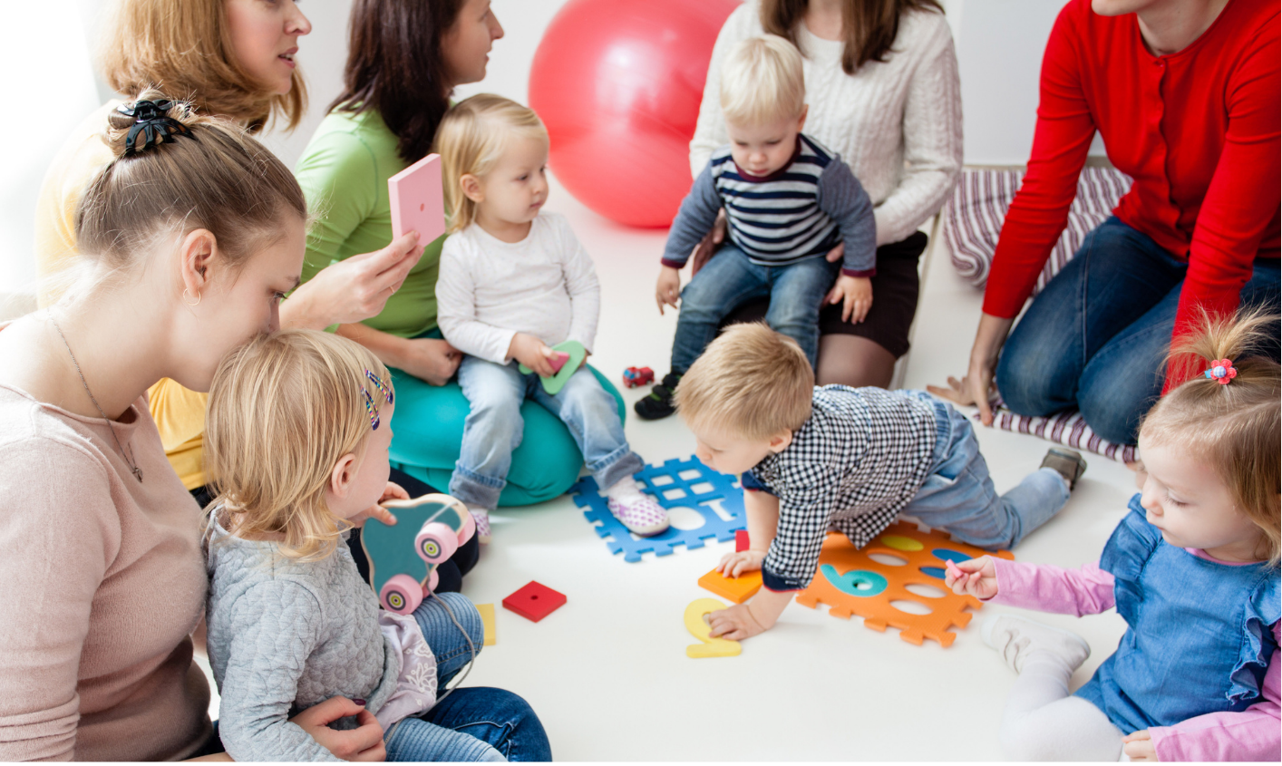A group of mums with their babies sitting in a circle playing