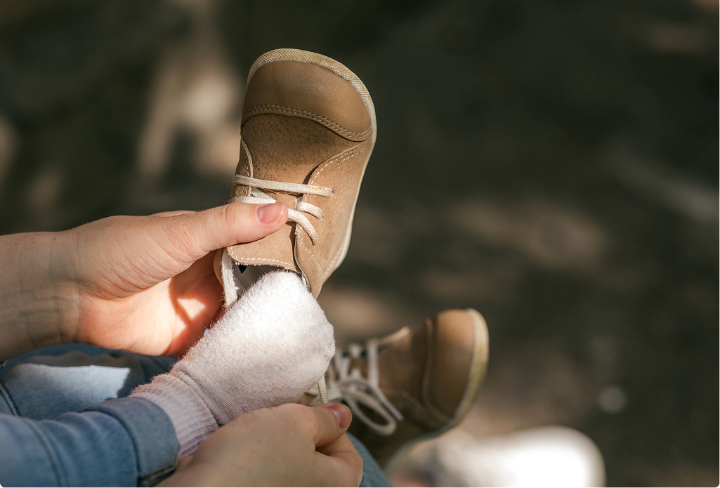 A babies foot being out into a shoe