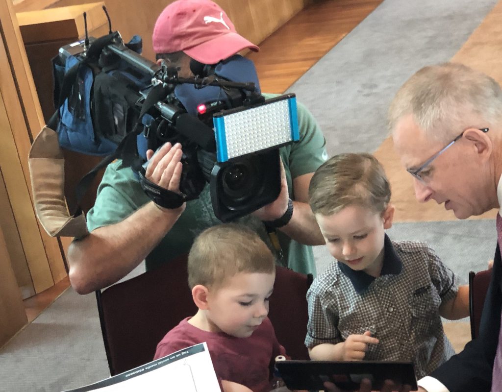 The Minister talking to children at an ESafety Meeting while a camera films in the background